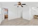 Bright bedroom featuring modern ceiling fan, light gray flooring, and an ensuite bathroom at 2325 W Knollwood Pl, Tampa, FL 33604