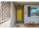 Close-up of the home's entry featuring a bright yellow front door and stylish exterior details at 2325 W Knollwood Pl, Tampa, FL 33604