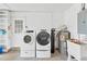 Bright laundry room featuring modern washer and dryer, with water heater and filter at 2325 W Knollwood Pl, Tampa, FL 33604