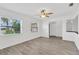 Bright living room featuring new flooring, fresh paint, and a modern ceiling fan at 2325 W Knollwood Pl, Tampa, FL 33604