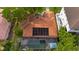 Aerial view of the backyard featuring a screened-in pool area, red tile roof, solar panels and lush greenery at 267 Snell Isle Ne Blvd, St Petersburg, FL 33704