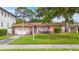 Charming pink home featuring a well-manicured front lawn, a mailbox, and a short driveway leading to an attached garage at 267 Snell Isle Ne Blvd, St Petersburg, FL 33704