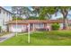 Charming pink home featuring a well-manicured front lawn, a mailbox, and a short driveway leading to an attached garage at 267 Snell Isle Ne Blvd, St Petersburg, FL 33704