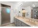 Bathroom featuring a double sink vanity, large mirror, and a tiled shower with glass door at 2708 W Bird St, Tampa, FL 33614