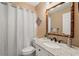 Traditional bathroom with decorative mirror, granite counters, and shower with curtain at 2708 W Bird St, Tampa, FL 33614