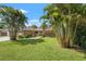 Spacious front yard with lush lawn, mature palm trees, and a brick home with stone accents at 2708 W Bird St, Tampa, FL 33614
