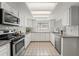 Well lit kitchen featuring stainless steel appliances, light granite countertops and tile flooring at 2708 W Bird St, Tampa, FL 33614