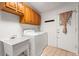 Bright laundry room with side-by-side washer and dryer, a utility sink, and backyard access at 2708 W Bird St, Tampa, FL 33614