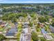 A residential neighborhood is shown from an aerial view, surrounded by lush green trees and foliage at 2708 W Bird St, Tampa, FL 33614