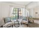 Cozy sitting area with patterned chairs, a round table and mirror walls reflecting sunlight and plants at 2708 W Bird St, Tampa, FL 33614