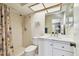Bright bathroom featuring tiled shower, white vanity with marble countertop, and skylight above at 2868 Denmarsh Ct, Palm Harbor, FL 34684