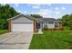 Charming single-story home with gray siding, brick accents, and an attached two-car garage at 2868 Denmarsh Ct, Palm Harbor, FL 34684