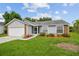 Well-maintained single-story house with gray siding, brick accents, and lush green lawn at 2868 Denmarsh Ct, Palm Harbor, FL 34684