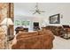 Inviting living room featuring stone fireplace, plush seating, and a ceiling fan for added comfort at 2868 Denmarsh Ct, Palm Harbor, FL 34684