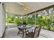 Inviting screened patio featuring a ceiling fan and a glass table set for outdoor enjoyment at 2868 Denmarsh Ct, Palm Harbor, FL 34684