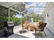 Enjoy outdoor living on the screened patio with seating, a grill, and views of the landscaped yard at 2868 Denmarsh Ct, Palm Harbor, FL 34684