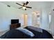 A comfortable bedroom featuring a ceiling fan, neutral carpet, bathroom access, and TV with console table at 3018 11Th N Ave, St Petersburg, FL 33713