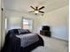 A cozy bedroom with a ceiling fan, neutral carpet and TV with console table at 3018 11Th N Ave, St Petersburg, FL 33713