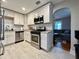 Updated kitchen features stainless steel appliances, white cabinets, and views to the living room at 3018 11Th N Ave, St Petersburg, FL 33713