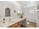 Well lit bathroom features a large mirror, wood cabinets, and wood-look flooring at 30260 Birdhouse Dr, Wesley Chapel, FL 33545