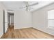 Bedroom with wood-look flooring, ceiling fan, and connecting doors at 30260 Birdhouse Dr, Wesley Chapel, FL 33545