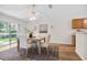 Dining area with modern table and chairs, sliding glass doors to the outside, and fan at 30260 Birdhouse Dr, Wesley Chapel, FL 33545