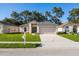 Charming single-story home featuring a well-manicured lawn, a two-car garage and a welcoming front entrance at 30260 Birdhouse Dr, Wesley Chapel, FL 33545