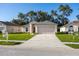 Single-story home with a well-manicured lawn and two-car garage at 30260 Birdhouse Dr, Wesley Chapel, FL 33545
