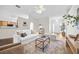 Bright, open living room with a white sofa, modern rug, and access to the kitchen at 30260 Birdhouse Dr, Wesley Chapel, FL 33545