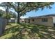 A spacious backyard with a mature tree has fencing and a storage shed with a patio at 3226 Coventry N, Safety Harbor, FL 34695