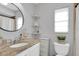 Cozy bathroom featuring a granite vanity, decorative shelves, and a toilet with a window view at 3226 Coventry N, Safety Harbor, FL 34695