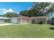 A well-maintained single-story home features a green lawn, garage, and neatly landscaped front yard at 3226 Coventry N, Safety Harbor, FL 34695