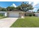 Inviting single-story home featuring a manicured lawn, attached two-car garage, and a welcoming entrance at 3226 Coventry N, Safety Harbor, FL 34695