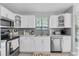 Modern kitchen featuring white cabinets, stainless steel appliances, and a stylish backsplash at 3226 Coventry N, Safety Harbor, FL 34695