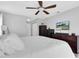 Comfortable main bedroom with ample storage, a ceiling fan, and a mounted television for entertainment at 3226 Coventry N, Safety Harbor, FL 34695