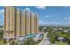 High-rise condo building with private balconies, covered parking, and vibrant yellow facade, nestled in a lush, tropical landscape at 345 Bayshore Blvd # 1510, Tampa, FL 33606