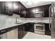 Kitchen with stainless steel appliances, dark cabinets, and marble countertops at 345 Bayshore Blvd # 1510, Tampa, FL 33606