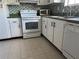 Well-lit kitchen with white cabinets, modern appliances, and tiled flooring for easy cleaning at 3535 41St S Ter # 219, St Petersburg, FL 33701