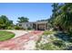 Charming one-story home featuring stone accents, a covered carport, and lush surrounding greenery at 3601 27Th S Ave, St Petersburg, FL 33711