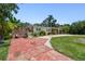 Single-story home with stone accents, mature landscaping, and a red driveway leading to a covered carport at 3601 27Th S Ave, St Petersburg, FL 33711