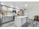 A modern kitchen features an island with marble countertop, gray cabinets, stainless steel appliances and gray wood floors at 3601 27Th S Ave, St Petersburg, FL 33711