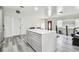 A modern kitchen features an island with marble countertop, gray cabinets and gray wood floors at 3601 27Th S Ave, St Petersburg, FL 33711
