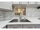A kitchen sink has modern faucet with white stone backsplash and countertop at 3601 27Th S Ave, St Petersburg, FL 33711
