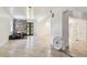 An empty living room with ceramic tile flooring, stone decor, and a front door with oval window at 3601 27Th S Ave, St Petersburg, FL 33711