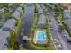 Aerial view showcases a community with a pool, pond, mature trees, and ample parking at 367 Countryside Key Blvd, Oldsmar, FL 34677