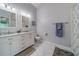Bathroom with double vanity, marble counters, soft gray walls, and a framed mirror at 367 Countryside Key Blvd, Oldsmar, FL 34677