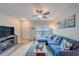 Comfortable living room with modern ceiling fan, light wood floors, and lots of natural light at 367 Countryside Key Blvd, Oldsmar, FL 34677