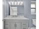 Bathroom showcasing a gray vanity with a marble countertop, a large mirror, and modern lighting at 3721 Casaba Loop, Valrico, FL 33596
