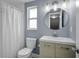 Bathroom featuring a wood vanity with a round mirror, a shower with curtain, and sleek fixtures at 3721 Casaba Loop, Valrico, FL 33596