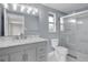 Renovated bathroom featuring a gray vanity with a marble countertop, a new shower, and sleek fixtures at 3721 Casaba Loop, Valrico, FL 33596